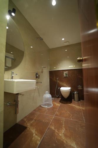 a bathroom with a sink and a toilet at THE CONTINENTAL INN & SUITES in Mysore