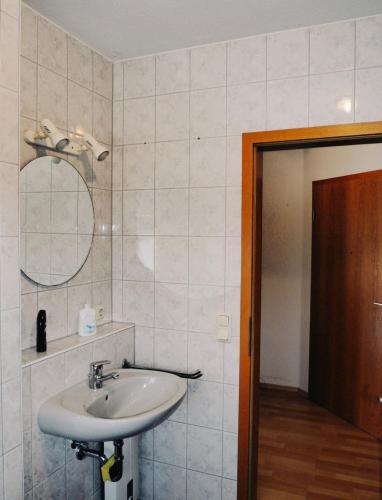 ein Bad mit einem Waschbecken und einem Spiegel in der Unterkunft FÜRTH/NÜRNBERG Monteurwohnung in Fürth