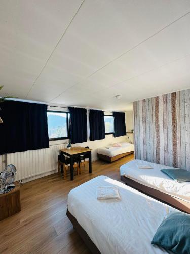 a room with two beds and a table in it at Le Coffee Ride Cycling Cafe in Stavelot