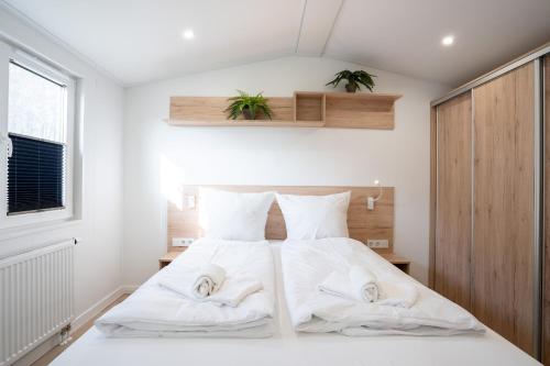 um quarto com uma cama com duas toalhas em Ostseecamp Ferienhaus "Wiesenblick" em Scharbeutz