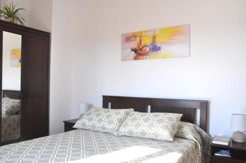 ein Schlafzimmer mit einem Bett und einem Gemälde an der Wand in der Unterkunft Ático Dúplex en Delta de l'Ebre dos terrazas y balcón in Deltebre
