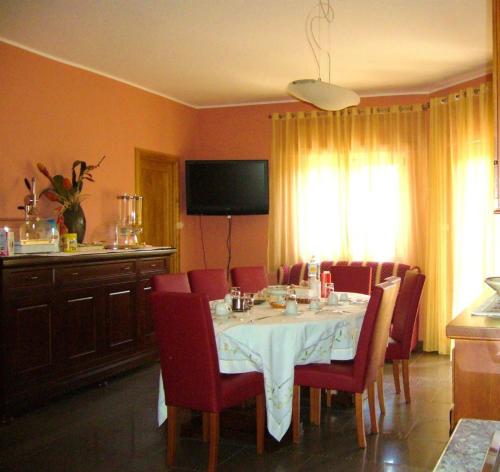 a dining room with a table and red chairs at Casa Del Sole in Soverato Marina