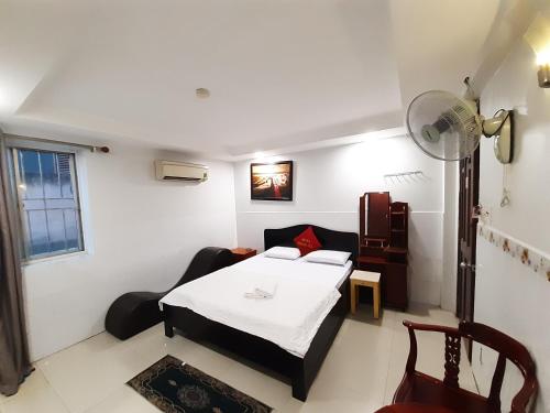 ein kleines Zimmer mit einem Bett und einem Sofa in der Unterkunft OYO 1226 Hoang Gia Hotel in Ho-Chi-Minh-Stadt