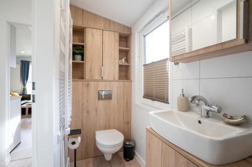 ein Badezimmer mit Waschbecken und Toilette in der Unterkunft Ostseecamp Ferienhaus "Sonneneck" mit umzäuntem Grundstück in Scharbeutz