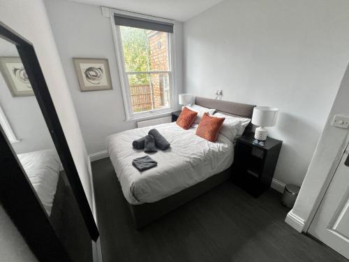 1 dormitorio con cama con almohadas y ventana en Oxford Bolthole, en Oxford