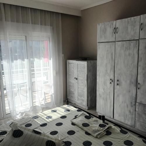 um quarto com uma cama, uma cómoda e uma janela em Olga's Studios Apartment3 em Michaniona
