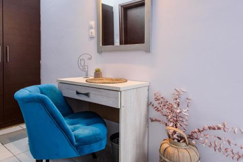 a bathroom with a blue chair and a vanity with a mirror at GIN Wellness Hotel in Pirgos
