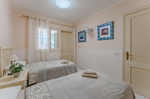een witte kamer met 2 bedden en een raam bij Great Apartment in Los Gigantes in Acantilado de los Gigantes