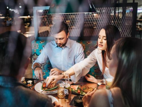 a man and woman serving food at a table in a restaurant at Original Sokos Hotel Viru in Tallinn