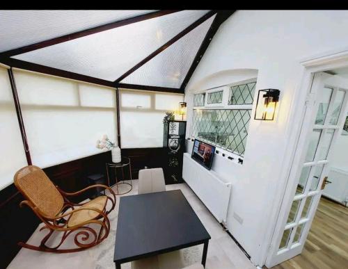 a living room with a table and a chair at COSY AND PRIVATE HOUSE CLOSE TO TOWN in Manchester