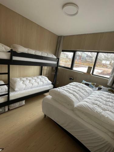 a bedroom with two bunk beds and a window at Beautiful lodge in Lofoten housing up to 6 guests! in Lyngværet