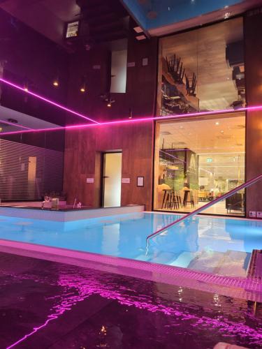 a large swimming pool in a building with purple lights at Villa6 in Pobierowo