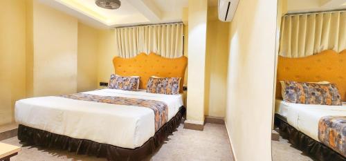 a hotel room with two beds and curtains at Hotel Nova Bling in Rajkot