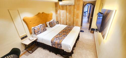 a bedroom with a large bed in a room at Hotel Nova Bling in Rajkot