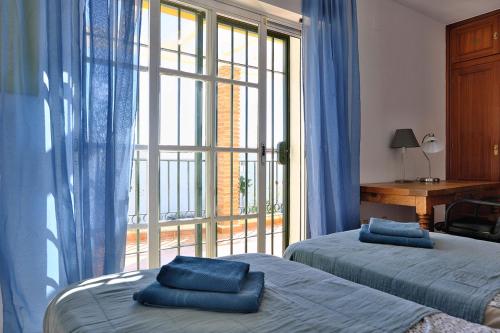 ラ・カラ・デ・ミハスにあるCasa Magda and Lukeのベッドルーム1室(ベッド2台、大きな窓付)