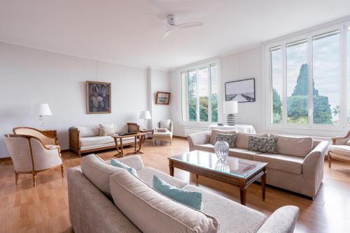 un salon avec des canapés, des tables et des fenêtres dans l'établissement LES PINS un havre de paix près de la plage, luxe pour familles ou petits groupes, à Cannes