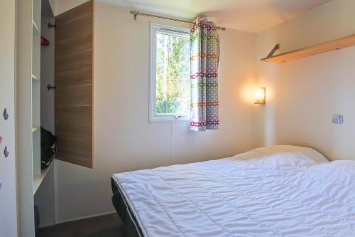 a bedroom with a bed and a window at New - Mobil home tout équipé in Saint-Jean-de-Monts