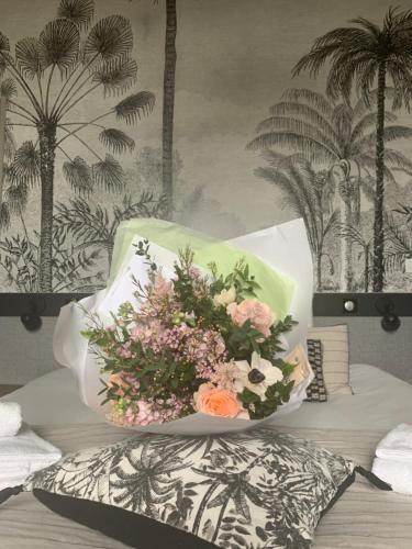 a bouquet of flowers sitting on top of a bed at Le Château des Forges in Angers