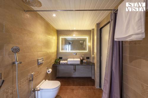 a bathroom with a toilet and a sink at StayVista's Rustique Radiance - Hillside Retreat with Outdoor Pool & South Indian Architecture in Khopoli