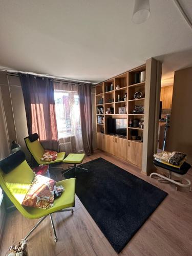 een woonkamer met 2 stoelen en een bank bij Roxy’s Kabin in Jelgava