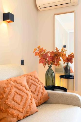 un canapé avec un oreiller et un miroir dans une pièce dans l'établissement Magnifique Appart Ac Terrasse-Plage à Pied-Parking privé, à Carqueiranne