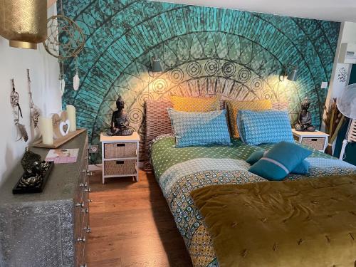a bedroom with a large bed with a headboard at Aux murmures de la nature B&B in Honfleur