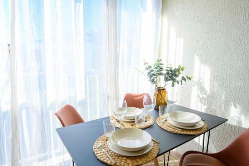 une table bleue avec des chaises, des assiettes et des verres dans l'établissement Magnifique Appart Ac Terrasse-Plage à Pied-Parking privé, à Carqueiranne