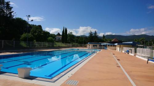 une grande piscine avec de l'eau bleue dans l'établissement Charmant appartement de 41m2 avec linges de maison et ménage compris, 2 pièces à Lamalou-les-Bains pour 2 personnes, à Lamalou-les-Bains