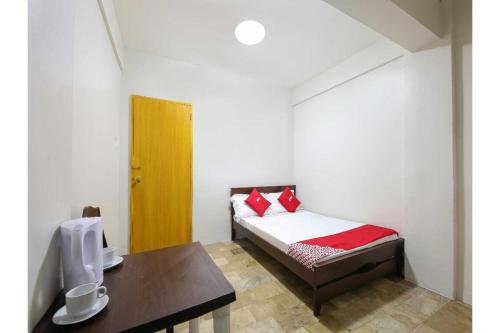 a small bedroom with a bed and a desk at OYO 1069 Cittatel Inn in Manila