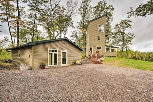 a house with a gravel driveway in front of it at Tower Lake Vacation Home & Cabin in Birchwood