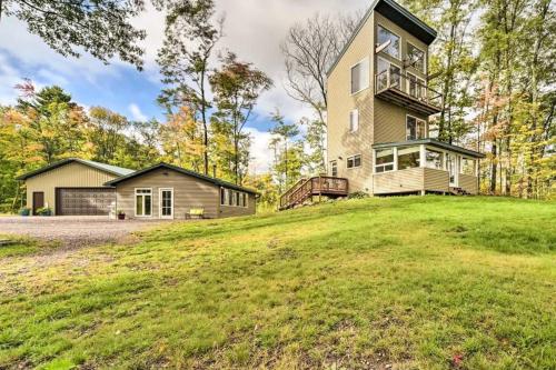 a large house on top of a grassy hill at Tower Lake Vacation Home & Cabin in Birchwood