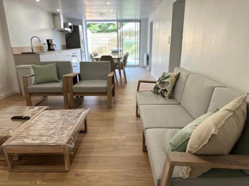 een woonkamer met een bank en een tafel bij Maison des années 1920 - à 150 m de l'océan et proche des commodités - 4 logements indépendants in Saint-Jean-de-Monts