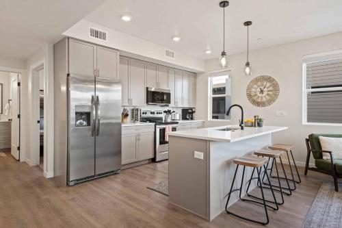 een keuken met een roestvrijstalen koelkast en witte kasten bij Palm Cove condo in Atkinville