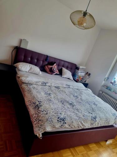 1 cama con cabecero púrpura en un dormitorio en Familien Haus, en Lucerna
