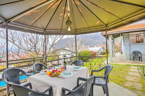 un tavolo sotto un grande ombrellone su un patio di Zio Enry Terrace Apartment Orta Lake - Happy Rentals ad Armeno
