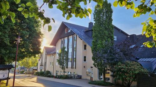 a large building with a black roof on a street at Landhotel Henkenhof Willingen in Willingen