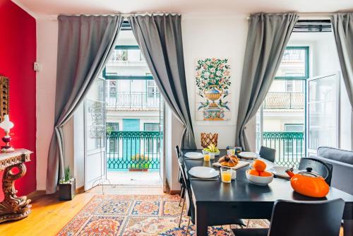 une salle à manger avec une table, des chaises et une grande fenêtre dans l'établissement Douradores Downtown Flat, à Lisbonne