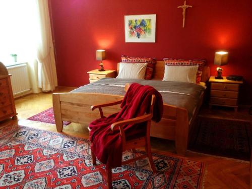 1 dormitorio con 1 cama con pared roja en Förster Appartements en Bad Vöslau