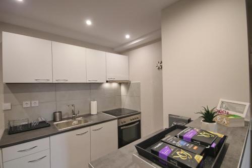 a kitchen with white cabinets and a sink at Villa Arcadia in Vlakhérna