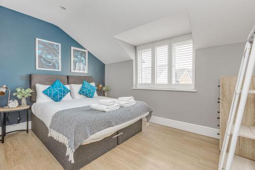 1 dormitorio con 1 cama con paredes azules en Stylish & Comfy 1 Bed Apt by Tent Serviced Apartments Egham - Town centre with parking and Wifi, en Egham