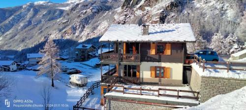 uma casa na neve com uma montanha em Appartamentinid em Valtournenche