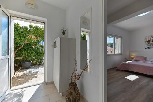 a bedroom with a bed and a large window at Apartments Kapetan in Trogir