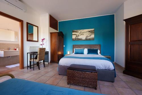 ein Schlafzimmer mit einem Bett und einer blauen Wand in der Unterkunft La Dolce Vita in Regalbuto