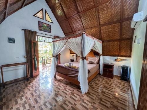 ein Schlafzimmer mit einem Himmelbett in einem Zimmer in der Unterkunft Sumatra Orangutan Treks Villa in Timbanglawang