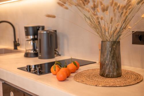 a group of oranges on a counter with a vase at Christini Secrets in Plátanos