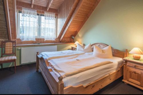 a bedroom with a bed and a chair in a room at Landhotel Weingut Schulze in Freyburg