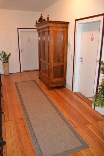 a room with a wooden cabinet and a rug at Jakobshof in Freckenfeld