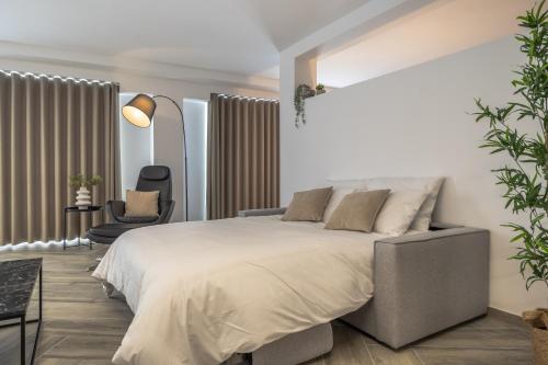 Un dormitorio con una cama grande y una silla. en The Cube - Designer finished studio by SF Homes, en Il-Gżira