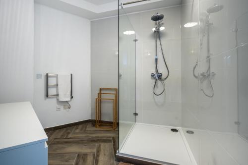 Un baño con ducha con puerta de cristal. en The Cube - Designer finished studio by SF Homes, en Il-Gżira