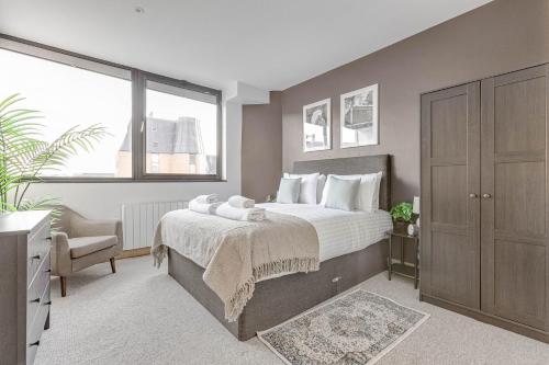 um quarto com uma cama grande e uma janela grande em Spacious 1 BR apt w 2 king bed by Tent serviced apartments em Farnborough